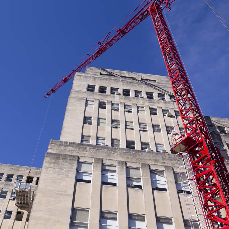 A crane lifts a piece of the building into place during renovations on Ballatine Hall.