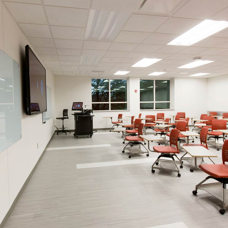 Classroom with rolling desks and a large monitor at the front of the room